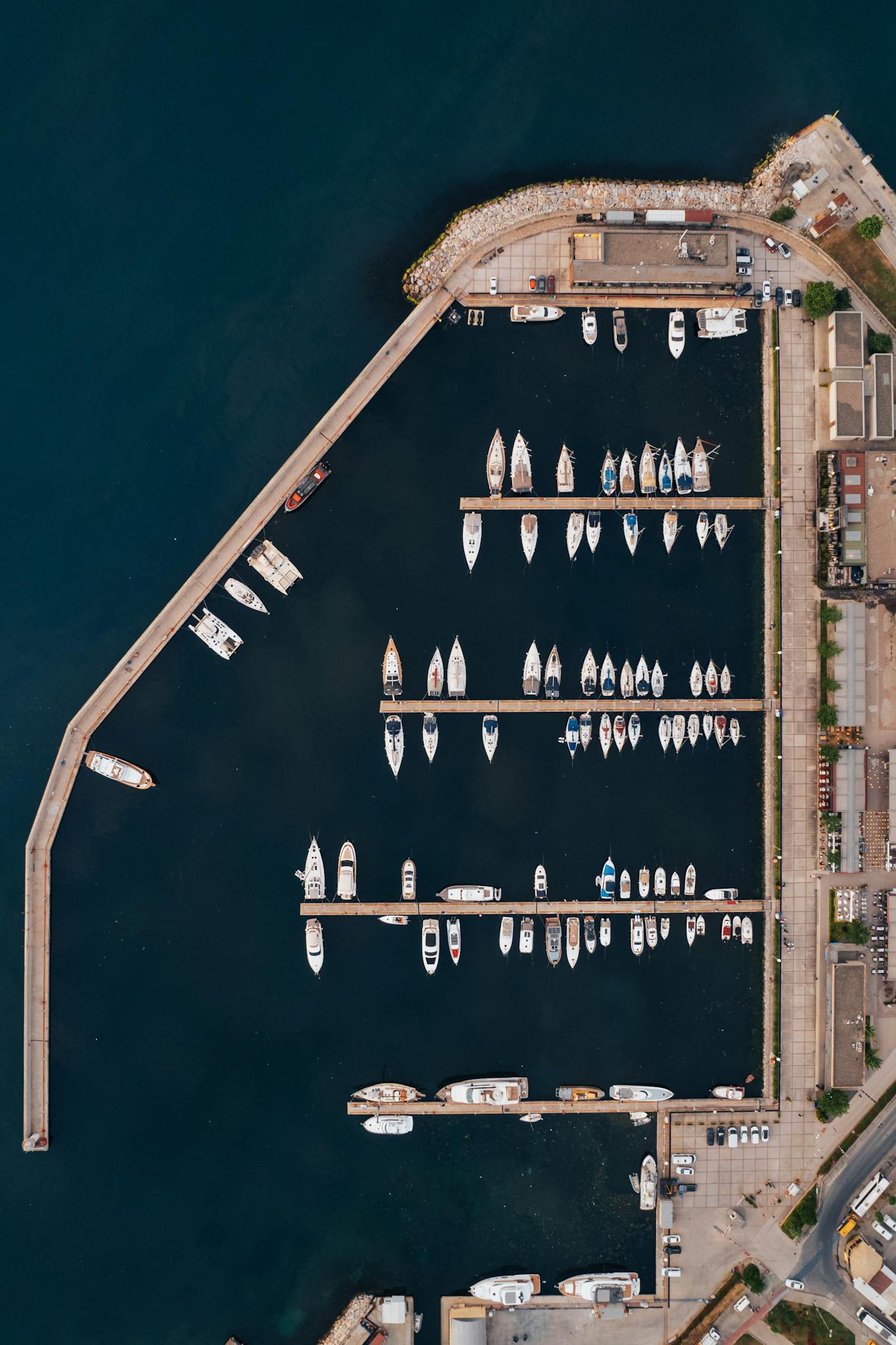Aerial photograph of boats docked at a marina harbor, showcasing an organized layout.